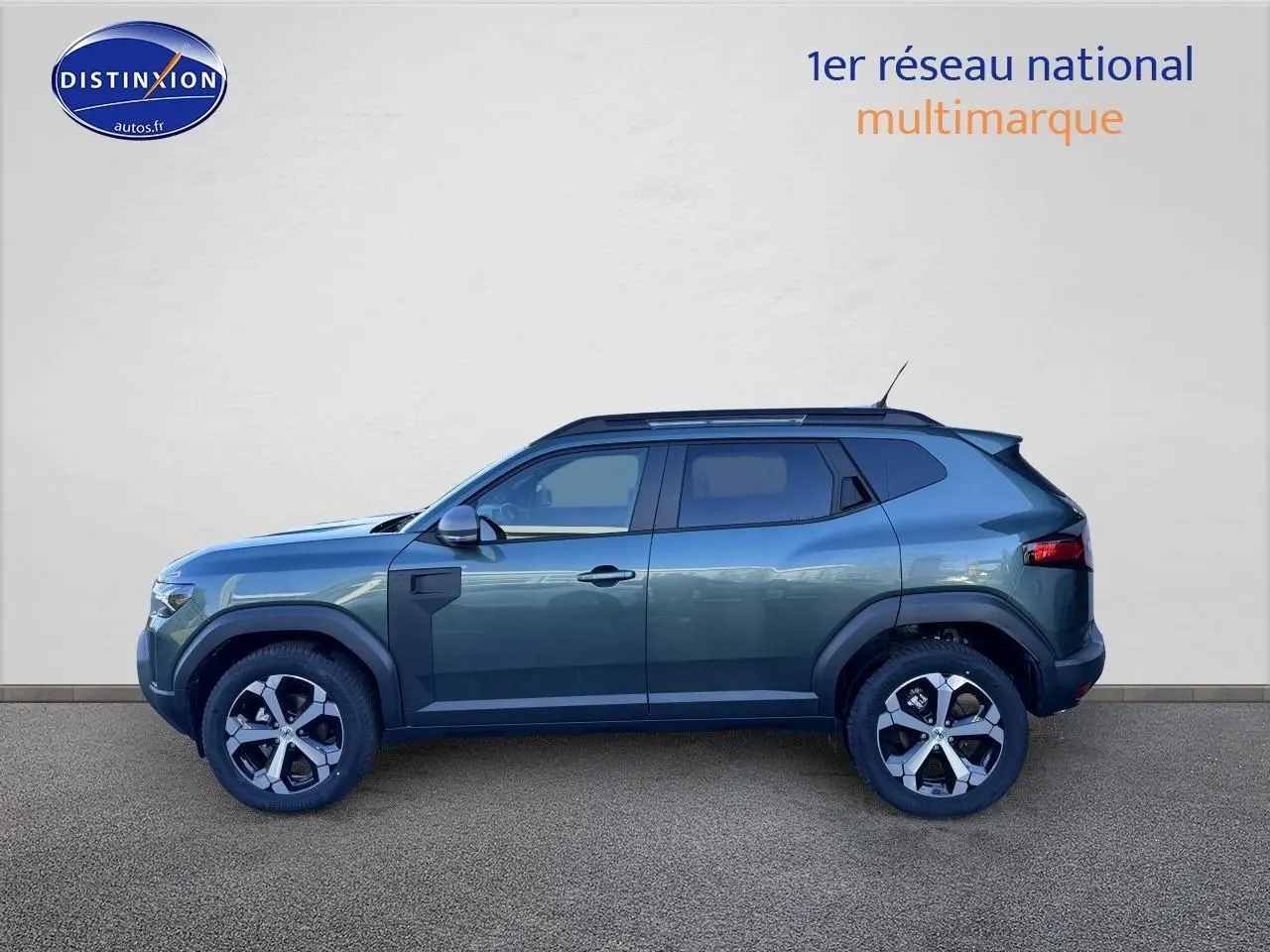 Profil latéral droit du Dacia Duster 2025 vert cèdre avec jantes alliage et barres de toit noires.