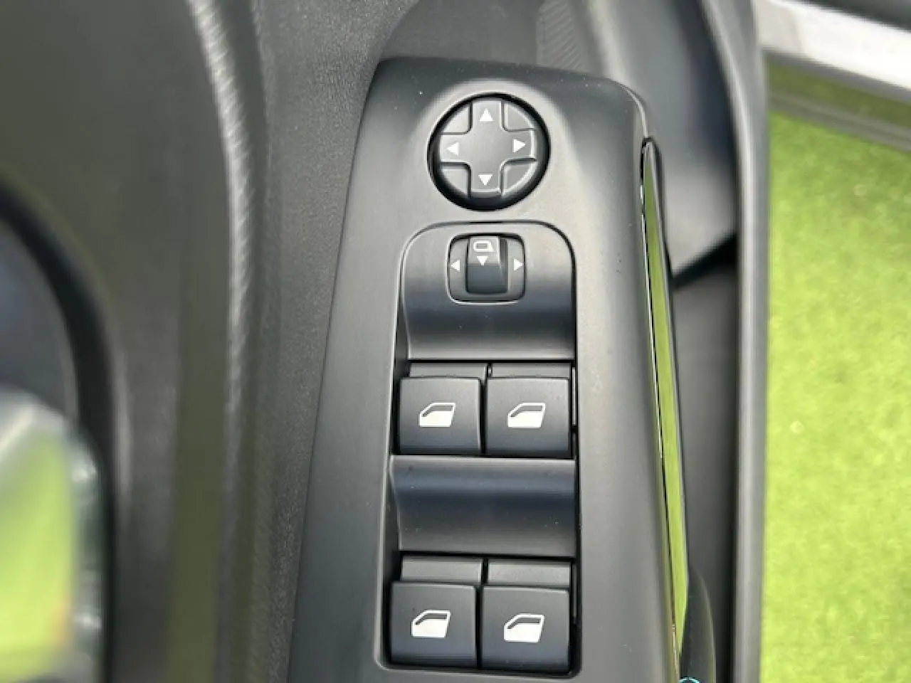 Gros plan sur les commandes de lève-vitres et réglage des rétroviseurs côté gauche d'une Citroën C5 Aircross 2025.