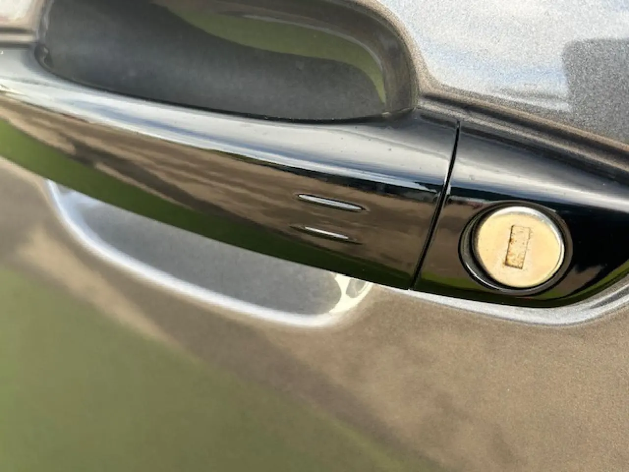 Poignée de porte noire brillante avec serrure sur la portière bleu eclipse métal du Citroën C5 Aircross 2025.
