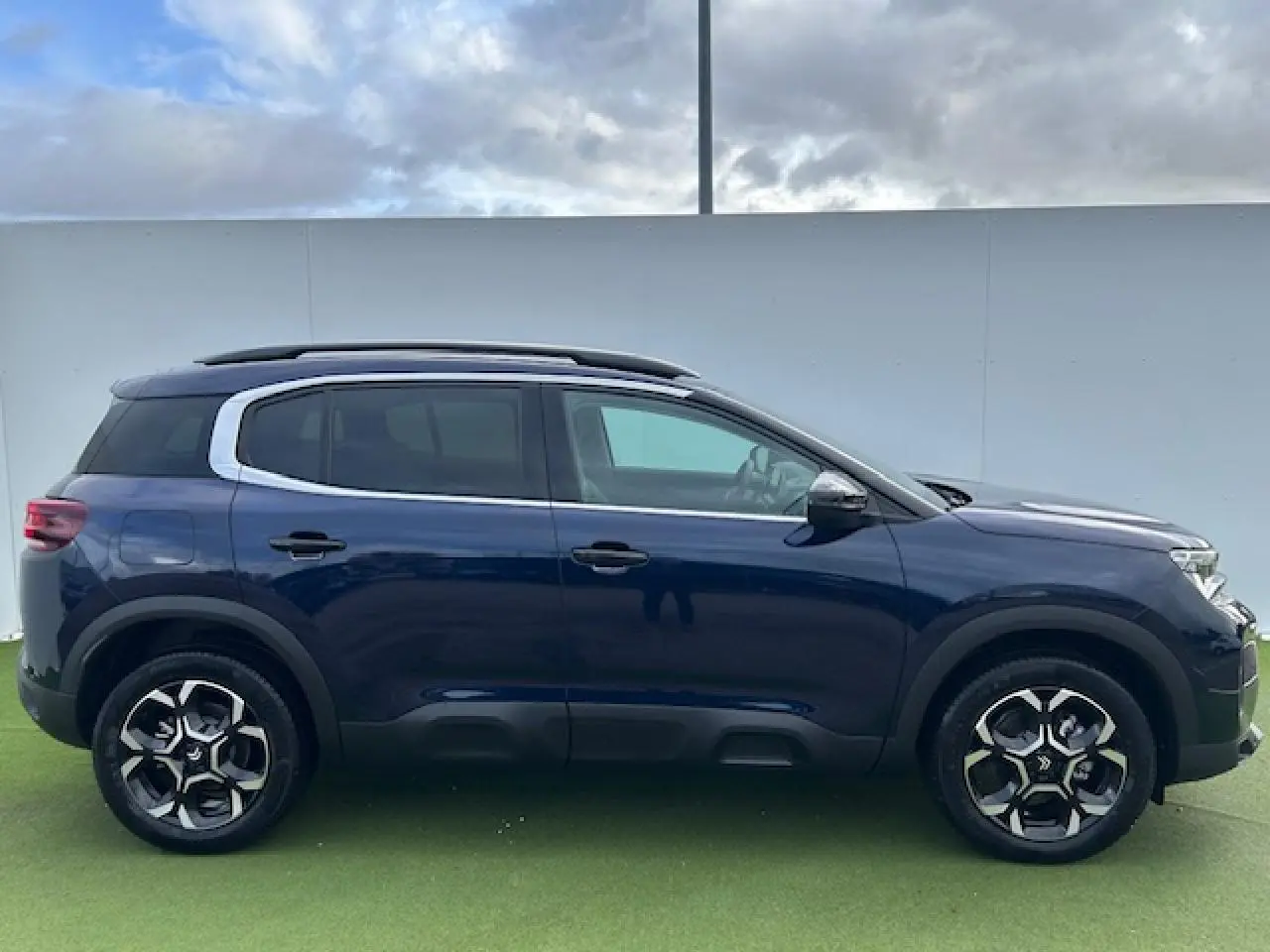 Profil droit du Citroën C5 Aircross bleu Eclipse métallisé avec jantes alliage 18 pouces et toit noir.