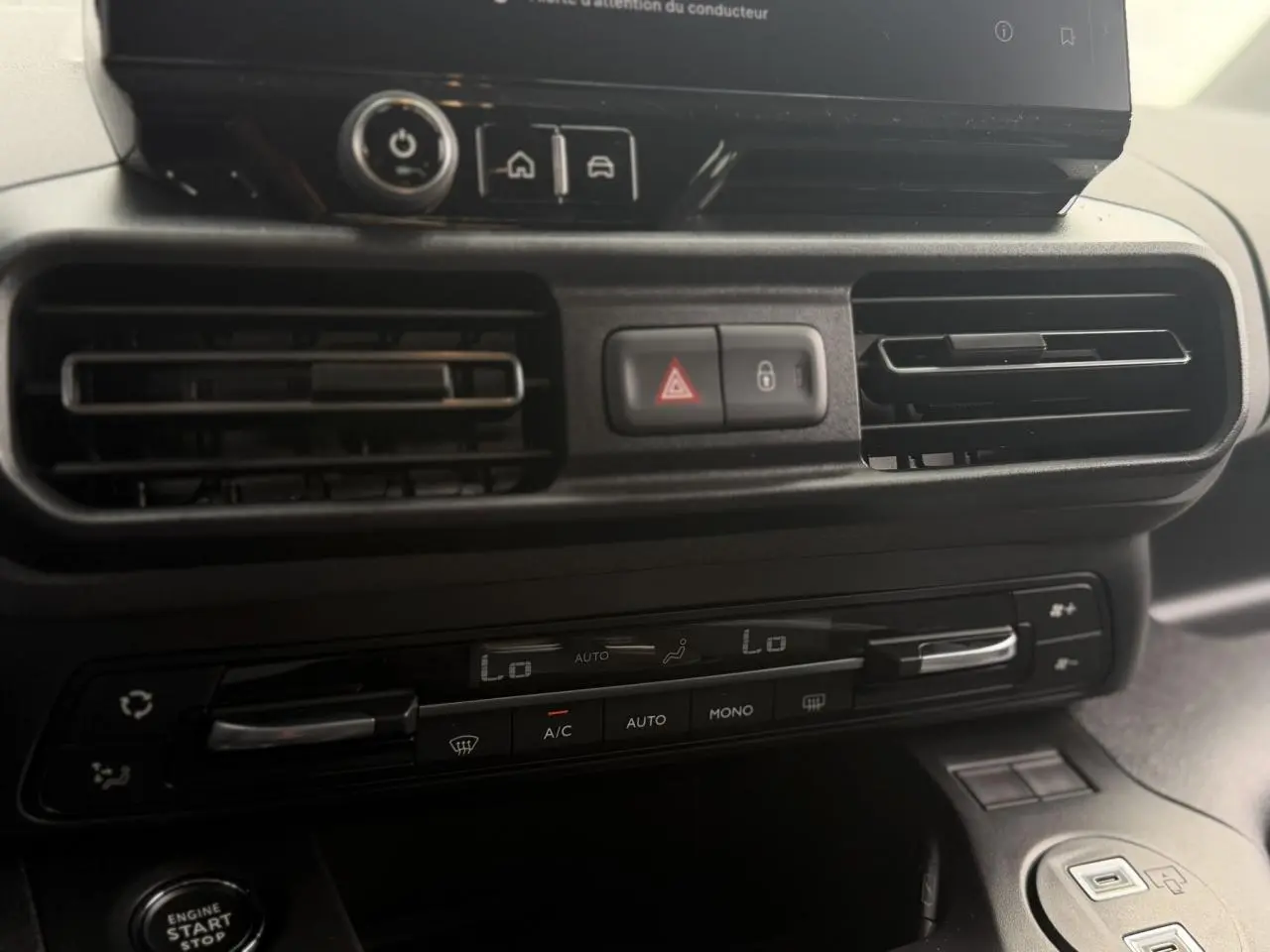 Gros plan sur la console centrale du Peugeot Rifter vert Sirkka 2026, montrant les commandes de climatisation et les aérateurs.