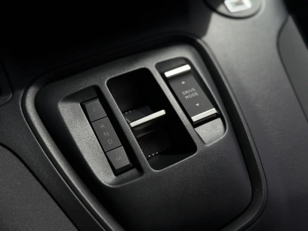 Gros plan sur la console centrale du Peugeot Rifter 2026, montrant la commande de boîte auto et le bouton Drive Mode.