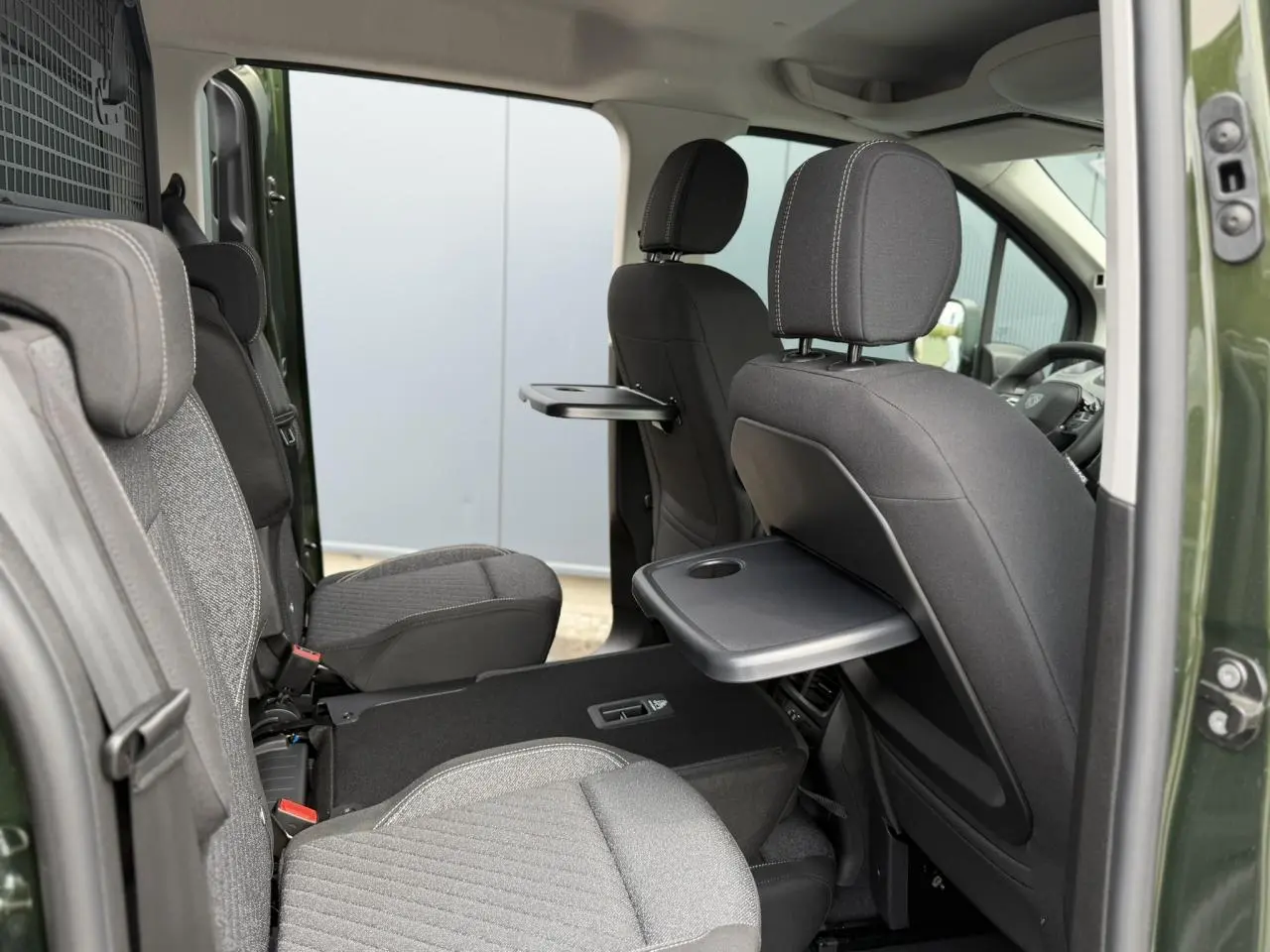 Vue intérieure côté droit du Peugeot Rifter Vert Sirkka 2026 avec sièges individuels et tablettes rabattables.