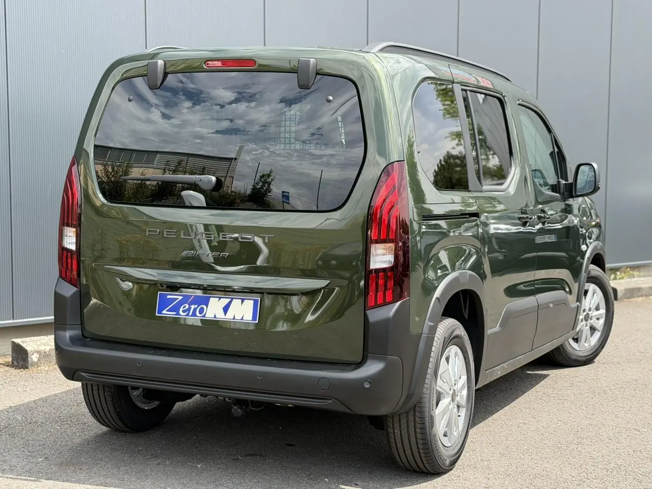 Vue 3/4 arrière droite du Peugeot Rifter vert Sirkka avec portes coulissantes et feux arrière LED distinctifs.
