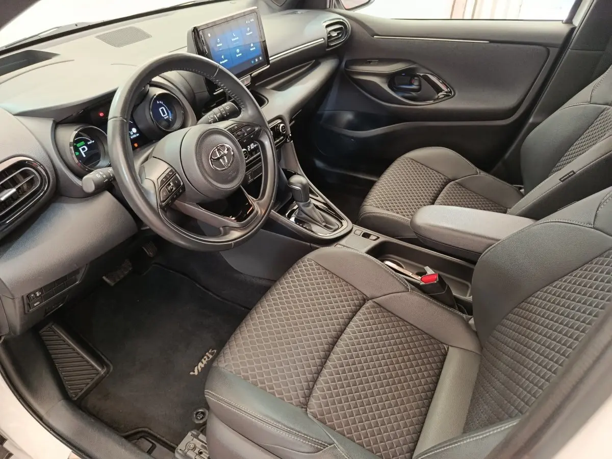 Vue intérieure côté conducteur de la Toyota Yaris Hybride 116h Collection 2022 avec écran tactile et sièges tissu gris.