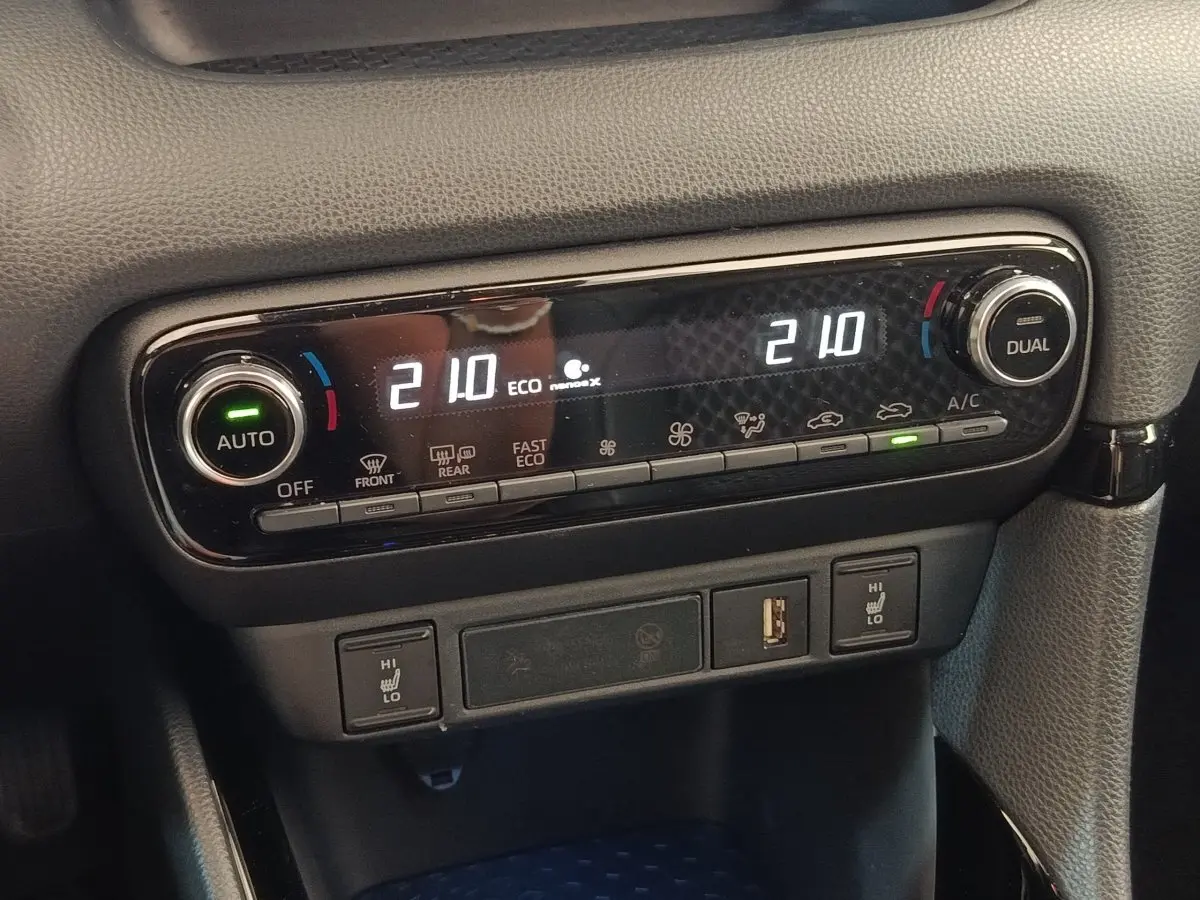 Gros plan sur la commande de climatisation automatique bi-zone avec affichage digital et réglages de température à 21°C.