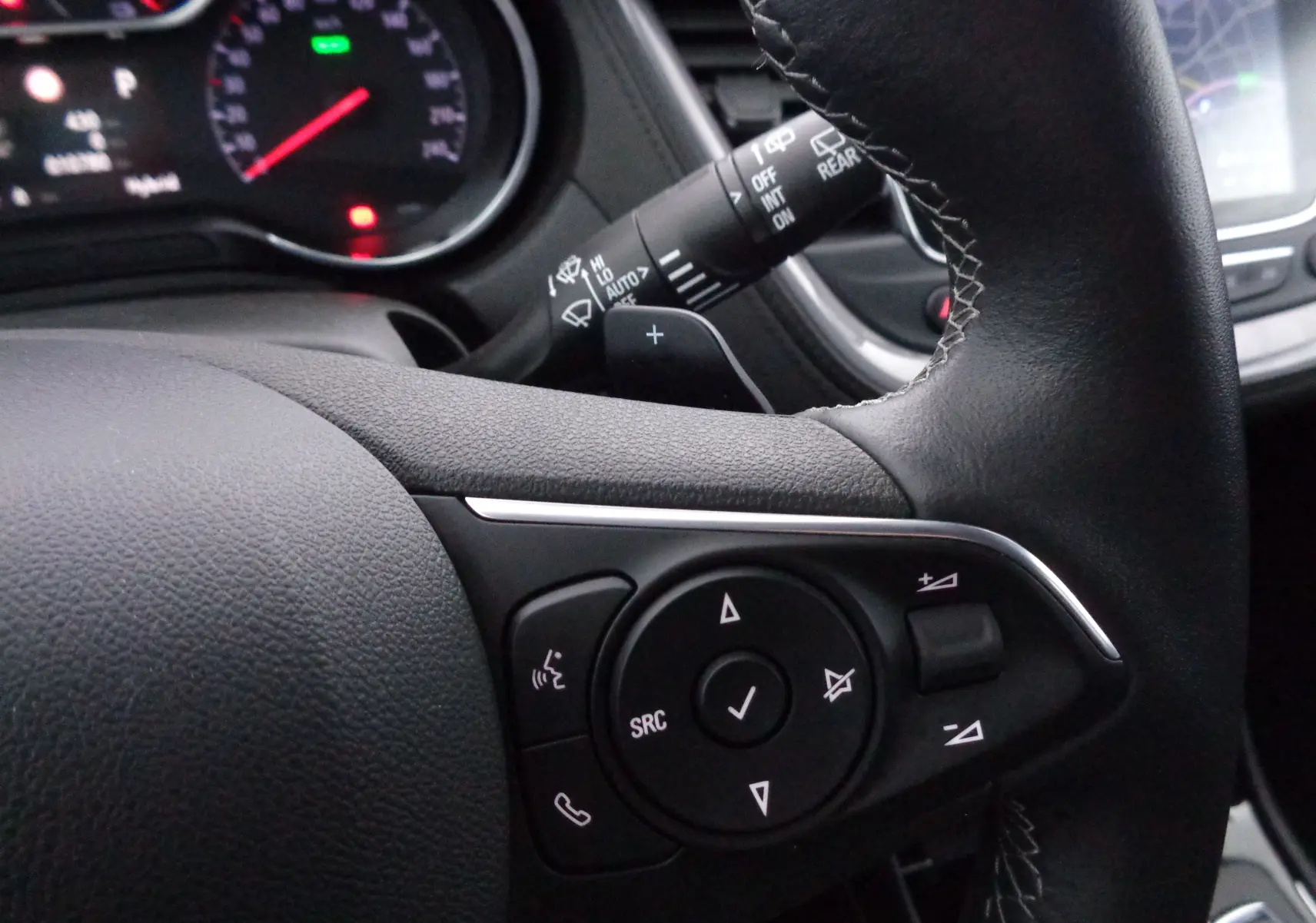 Gros plan sur le volant noir de l'Opel Grandland X 2021, montrant les commandes multimédia côté gauche.