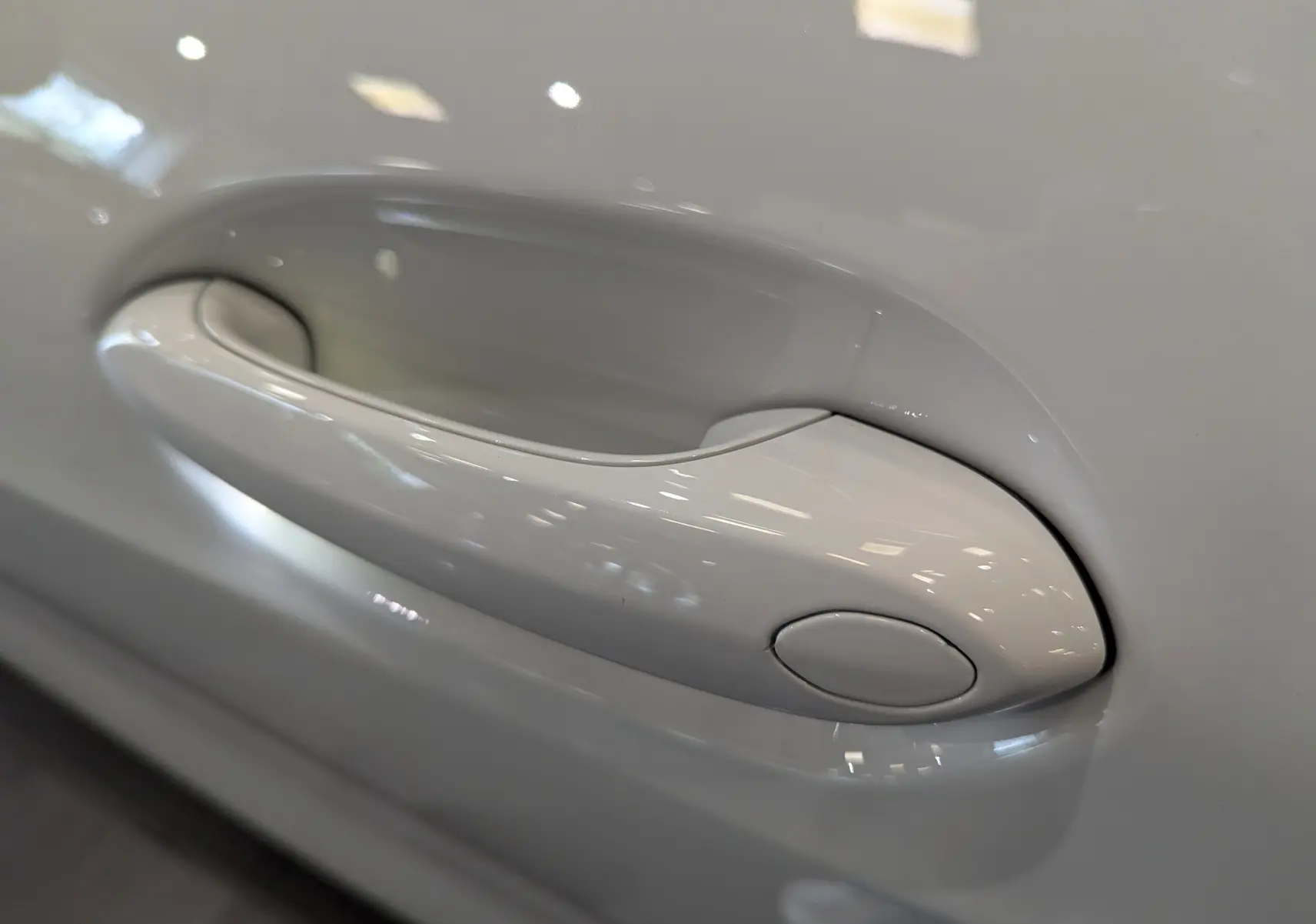 Poignée de porte blanche alpin en gros plan sur une BMW Série 1 F40 18d 2023 finition M Sport.