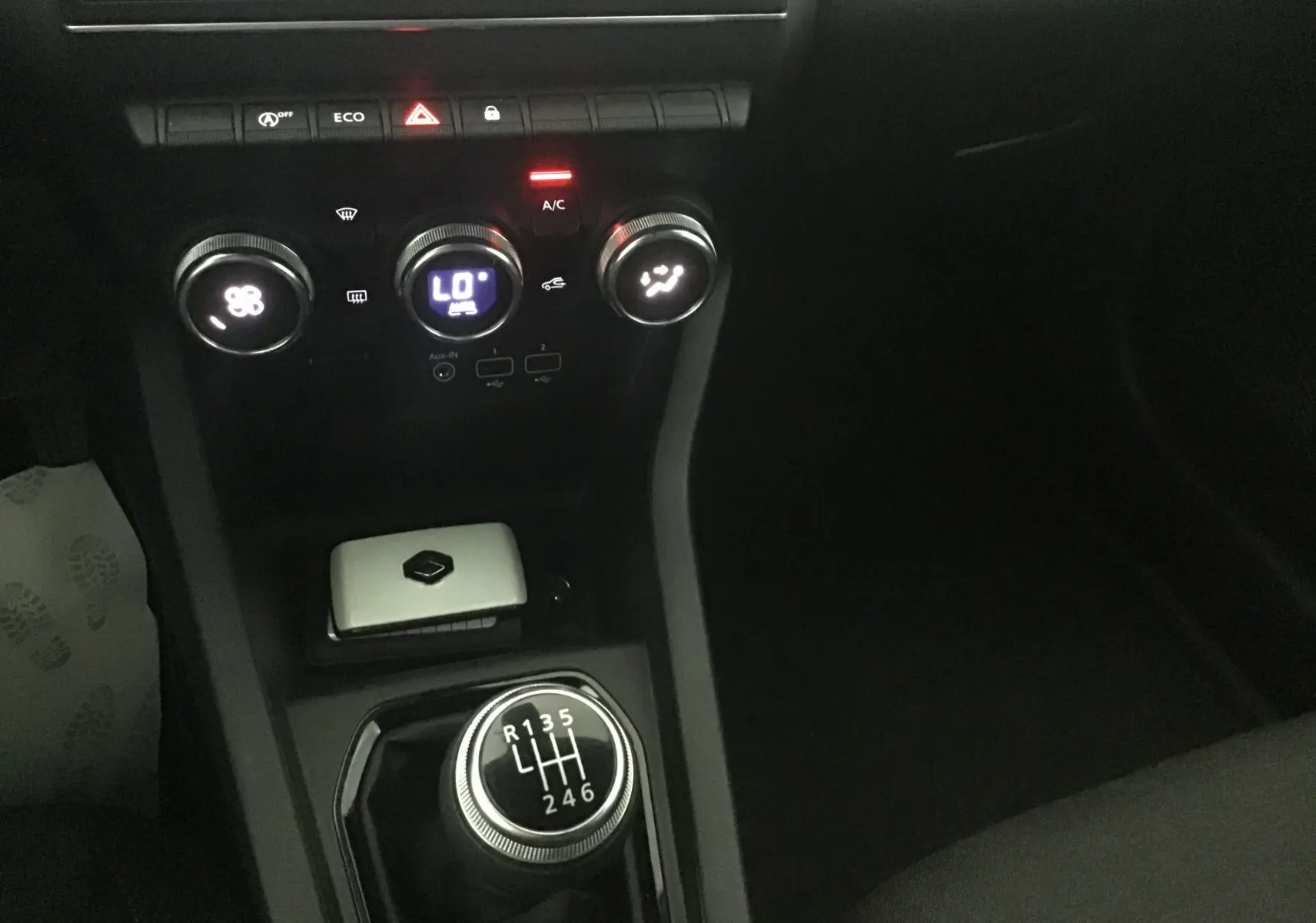 Gros plan sur la console centrale de la Renault Clio V 1.0 TCE 90 Zen, avec levier de vitesse manuel et commandes de climatisation.
