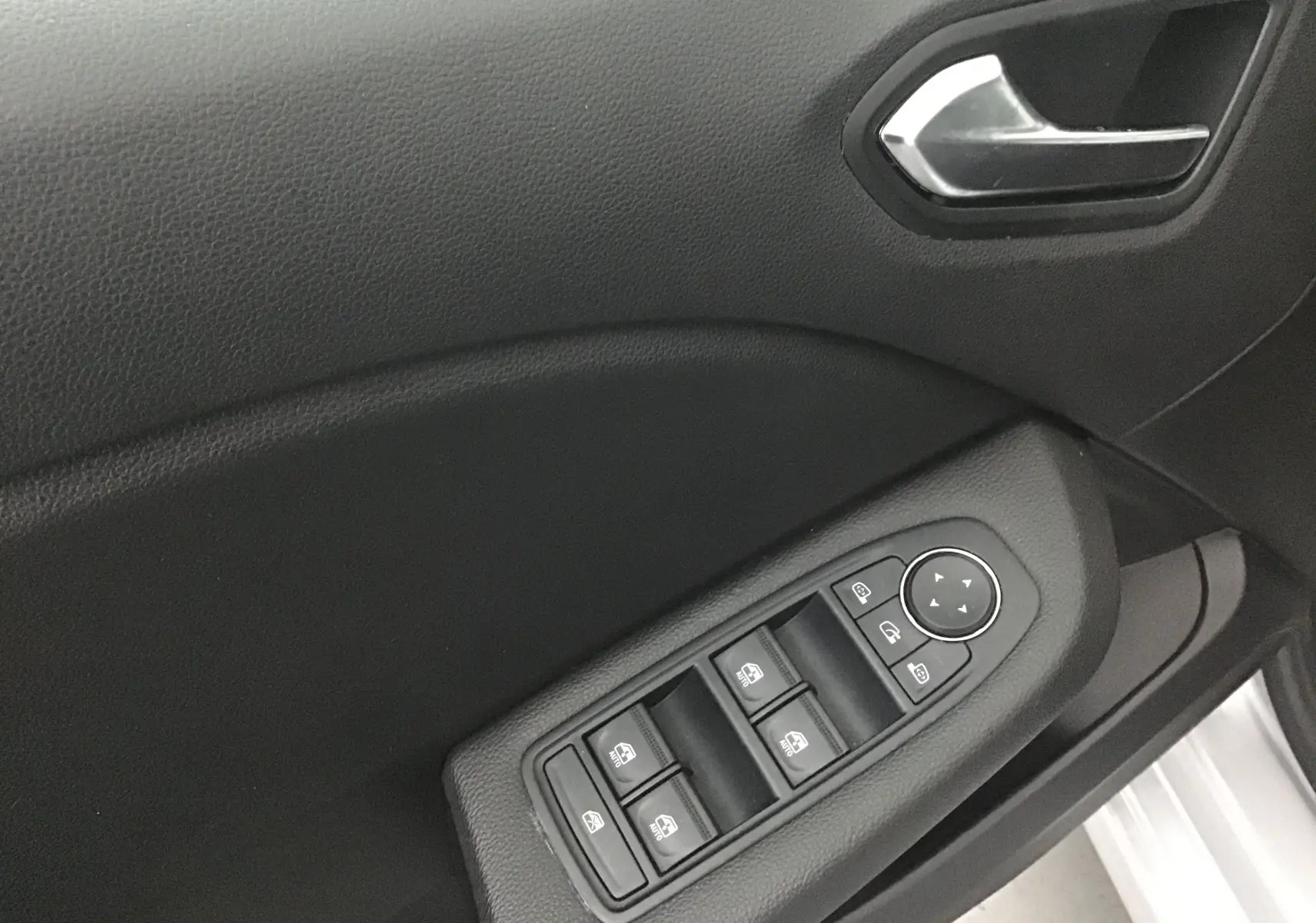 Panneau de porte côté gauche de la Renault Clio V gris platine, avec commandes électriques des vitres et poignée intérieure.