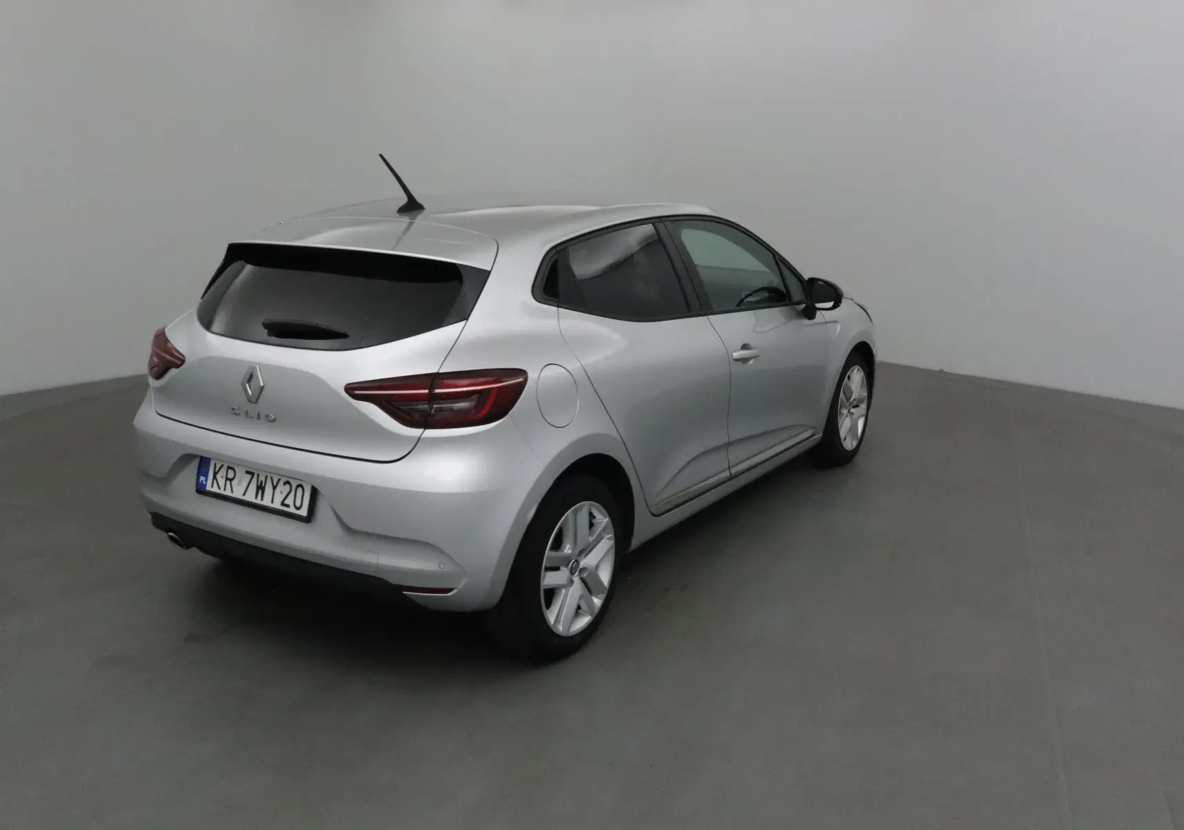 Renault Clio V gris platine vue 3/4 arrière droit, avec feux LED et vitres arrière teintées.