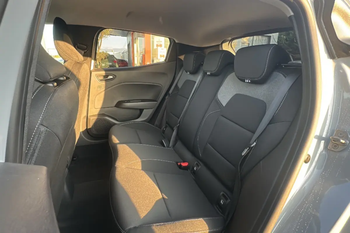 Vue intérieure côté droit des sièges arrière noirs avec surpiqûres blanches d'une Renault Clio Gris Rafale 2025 DCI 100 Evolution Camera.
