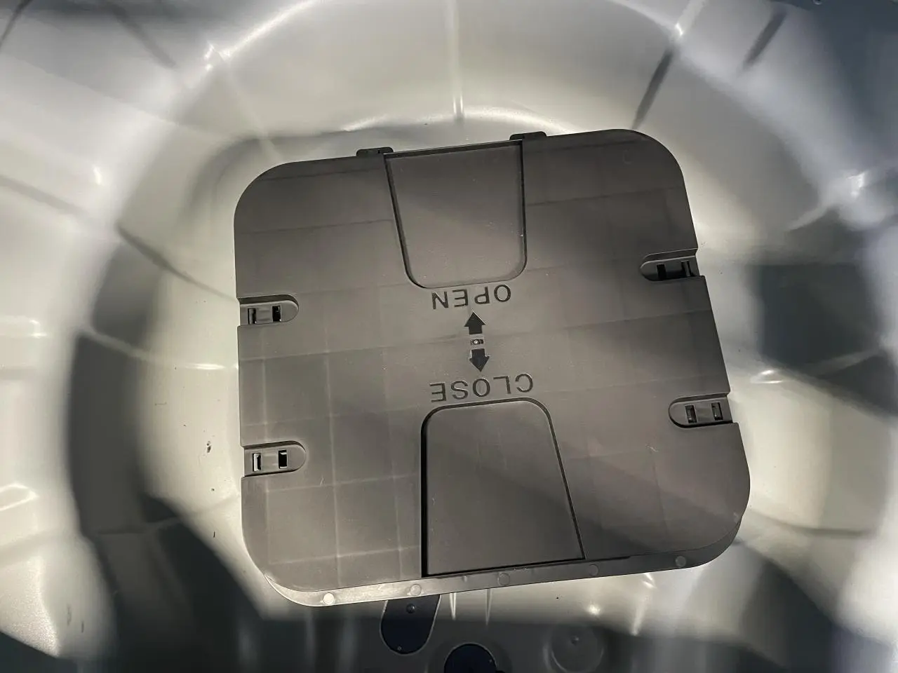 Vue en plongée sur le coffre gris Rafale de la Renault Clio 1.5 Blue dCi 2025 avec compartiment de rangement fermé.