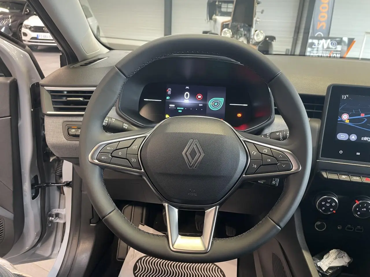 Vue intérieure centrée sur le volant noir de la Renault Clio 1.5 Blue dCi 2025 avec tableau de bord numérique et écran tactile.