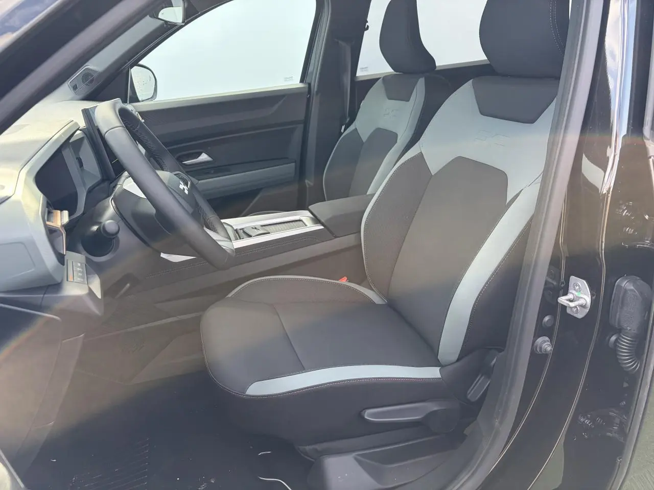 Vue intérieure côté conducteur de la Dacia Bigster noire, avec sièges Extreme TEP MicroCloud bicolores gris et noir.