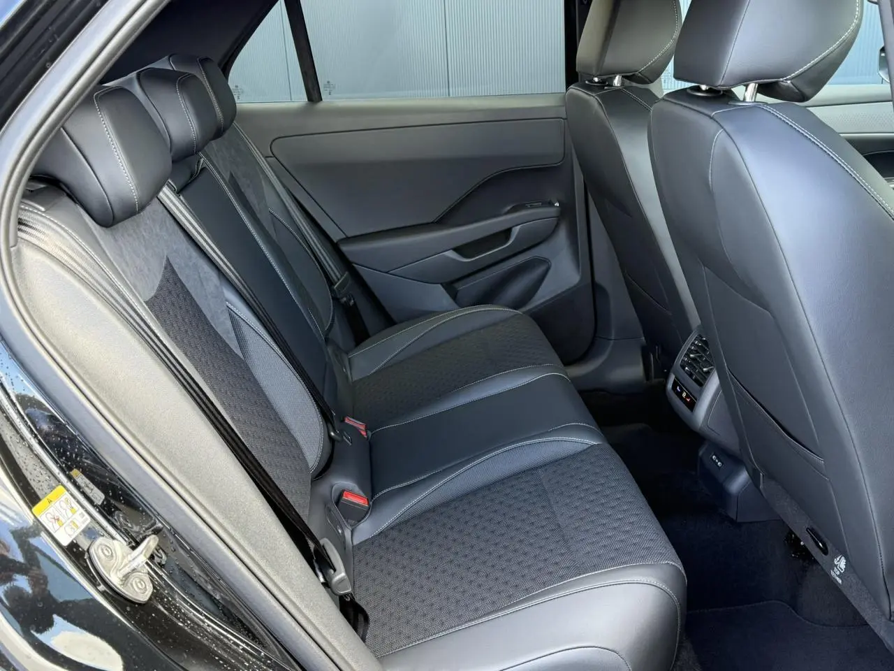 Vue côté gauche de la banquette arrière en tissu noir et cuir du Volkswagen T-Roc 2026 finition R-Line.