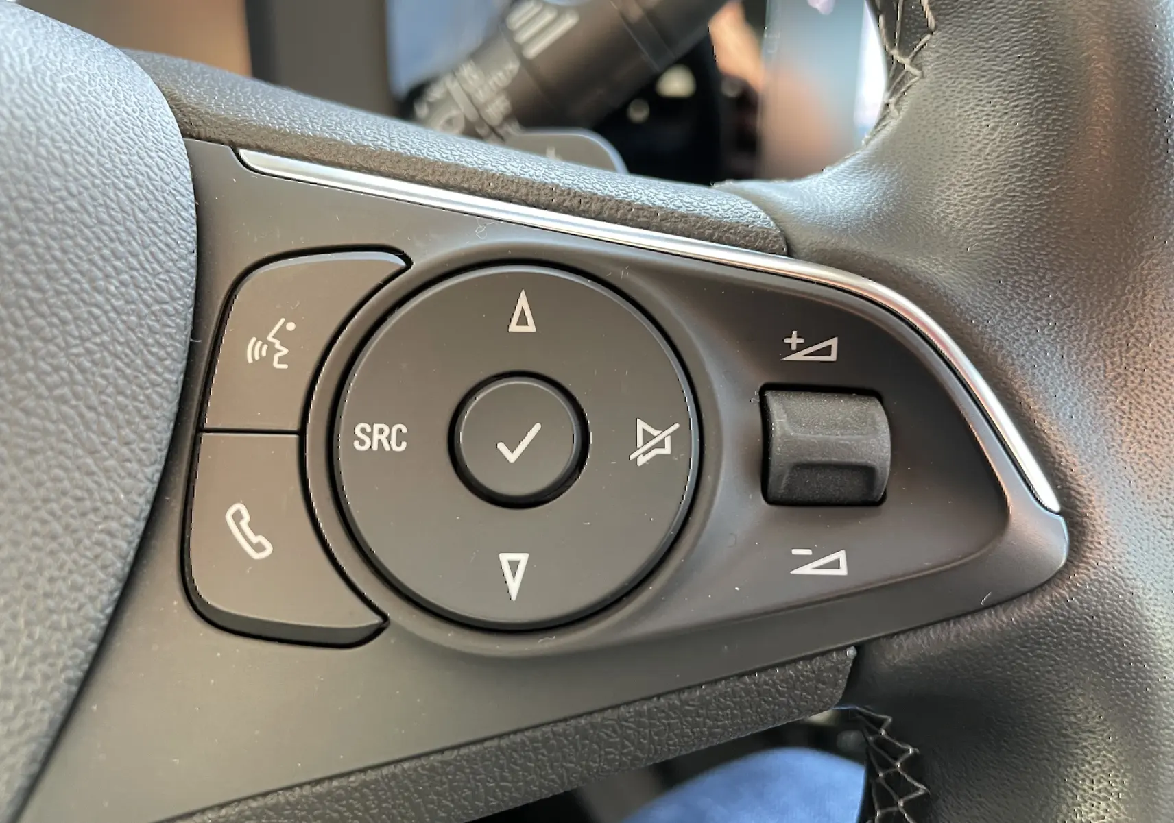 Gros plan sur les commandes du volant noir de l’Opel Mokka 2023, version Elegance Business.