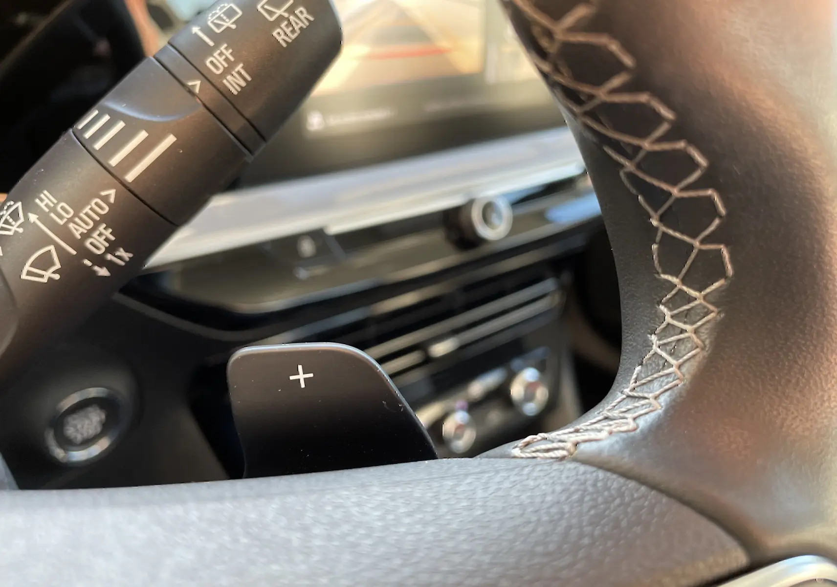 Gros plan sur la palette de changement de vitesse droite et la commande d’essuie-glace du tableau de bord intérieur d’un Opel Mokka bleu Voltak 2023.