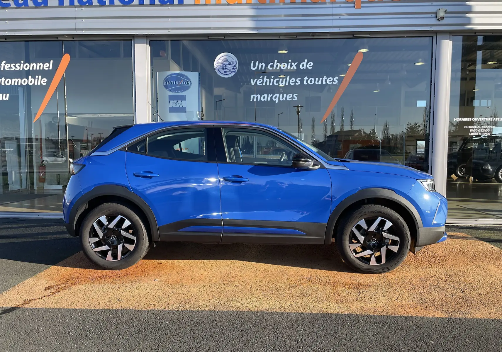 Vue latérale droite d'un Opel Mokka 2023 bleu Voltak, avec jantes noires et détails noirs contrastants.
