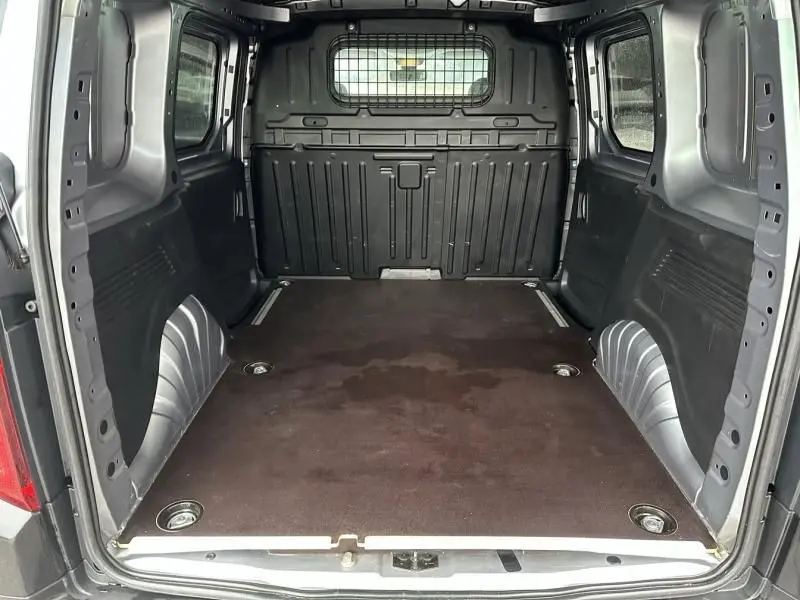 Vue intérieure arrière du Citroën Berlingo van gris métal 2020, montrant l'espace de chargement vide avec cloison métallique.