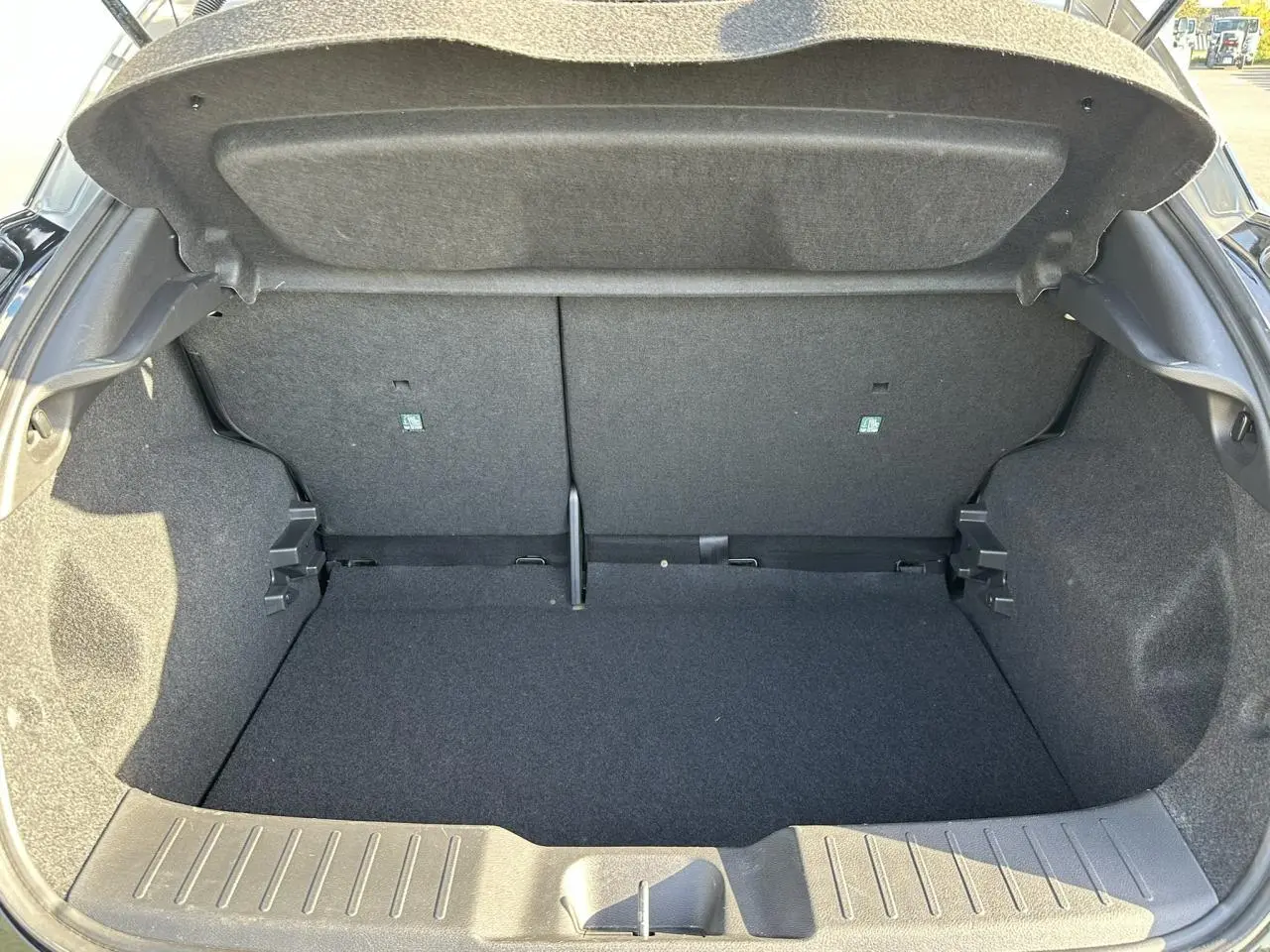 Coffre ouvert noir du Nissan Juke 2025, vue intérieure arrière montrant l'espace de chargement vide et doublure grise.