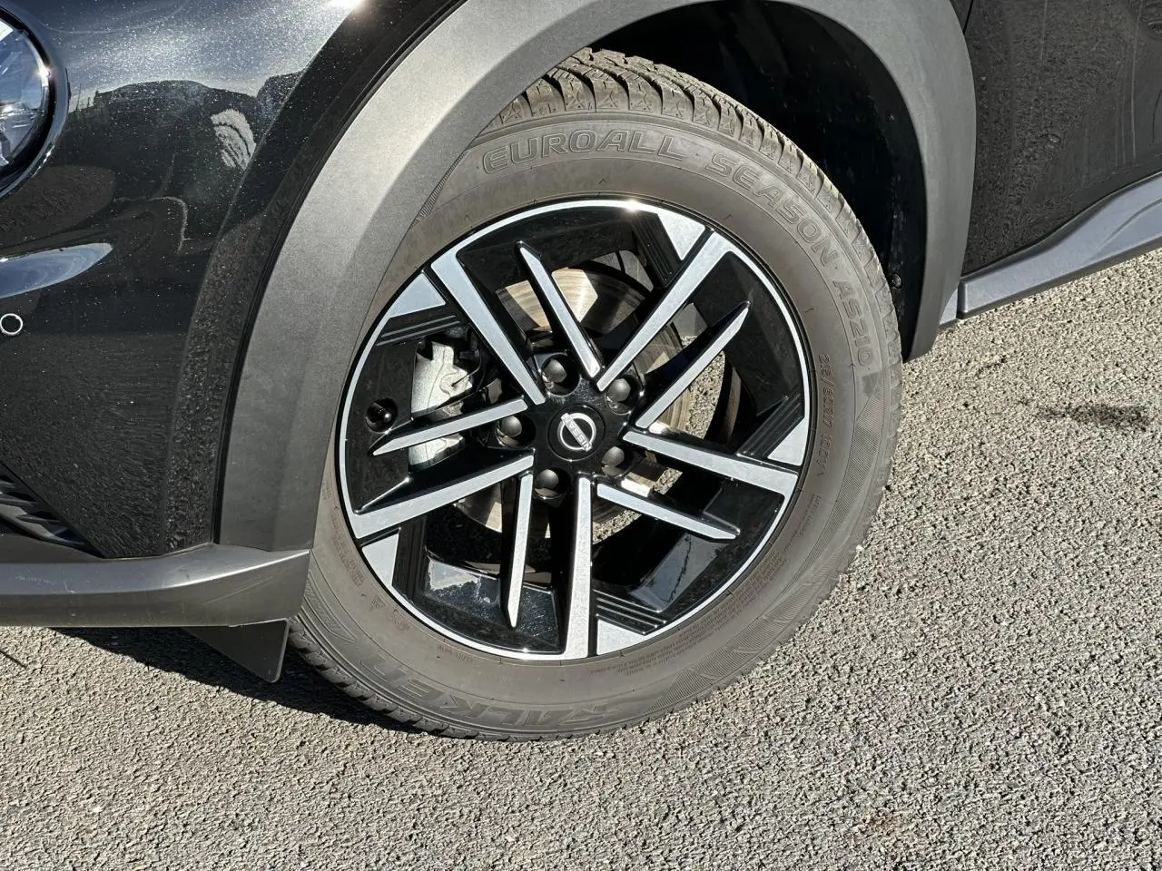 Gros plan sur la jante alliage 17'' noire et argentée du côté avant droit du Nissan Juke noir 2025.