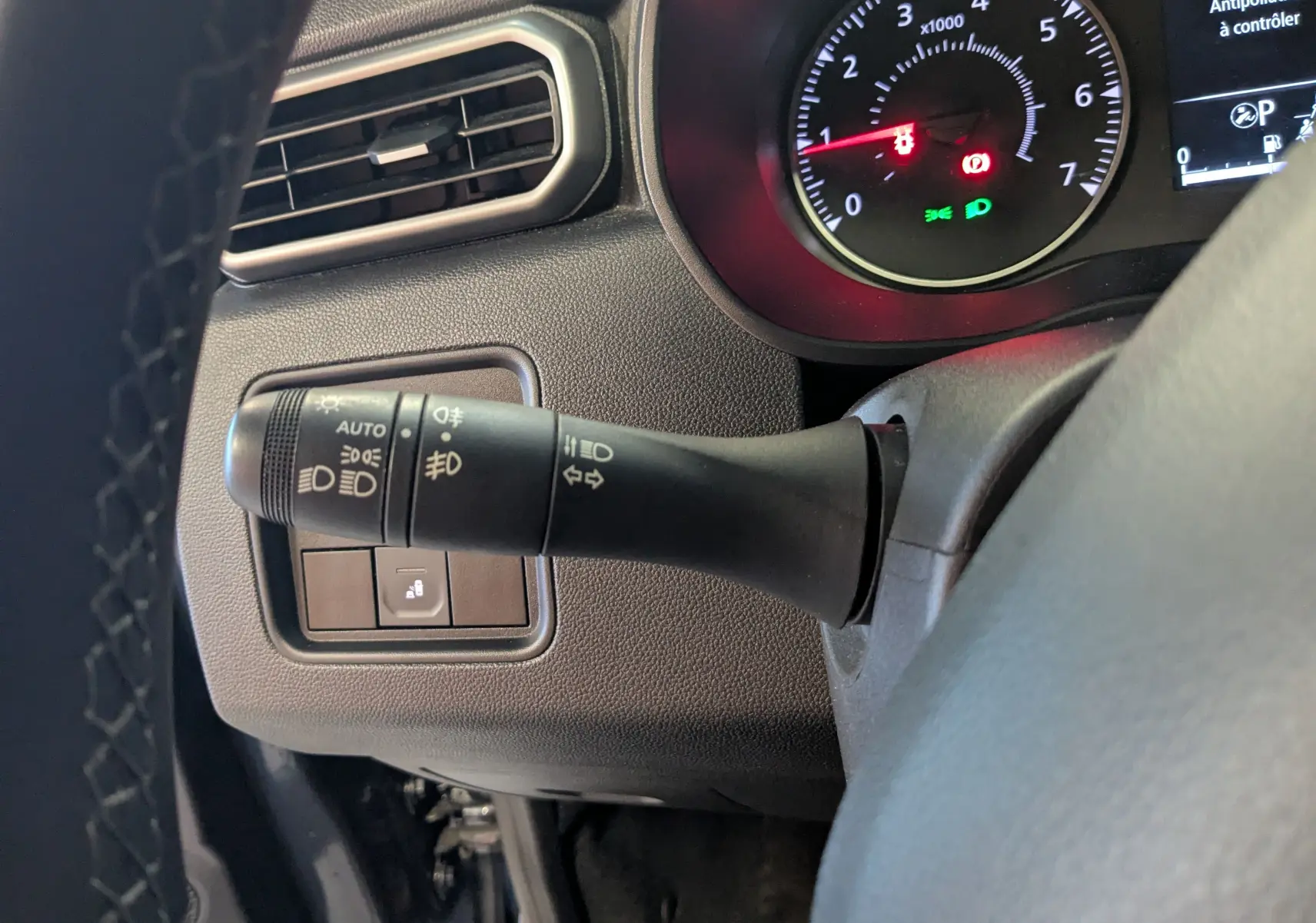 Gros plan sur la commande des phares et clignotants à gauche du volant du Dacia Duster 2023, intérieur noir.