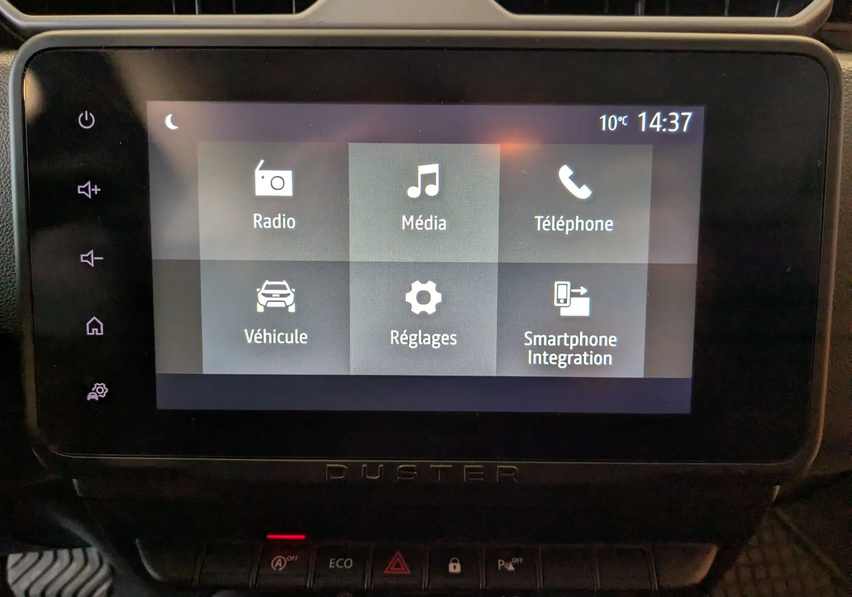 Écran tactile central du tableau de bord du Dacia Duster 2023 affichant les menus Radio, Média, Téléphone, Véhicule, Réglages et Smartphone Integration.