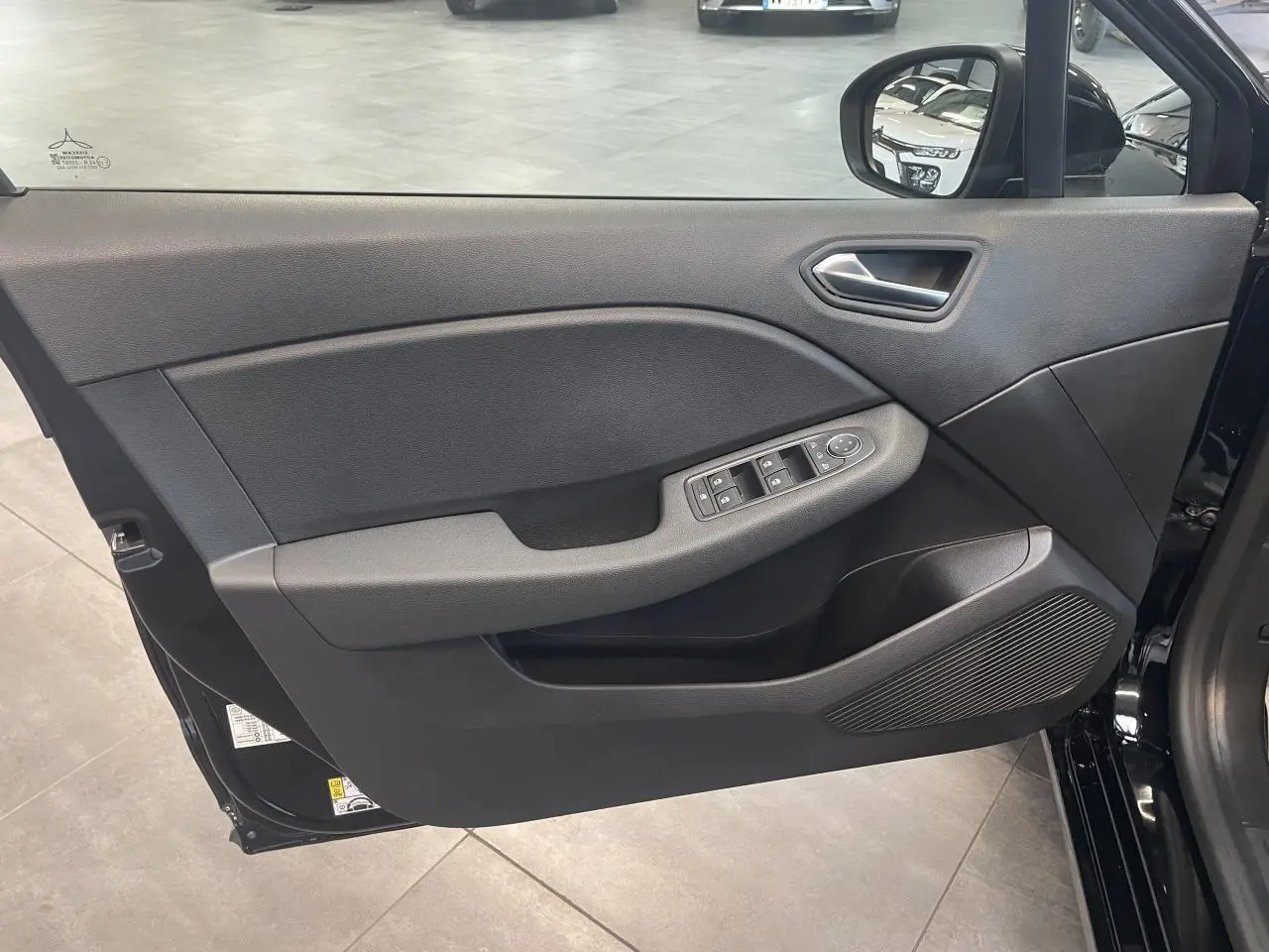 Vue intérieure de la porte avant gauche noire étoile de la Renault Clio 1.5 Blue dCi 2025 avec commandes de vitres et rétroviseur.