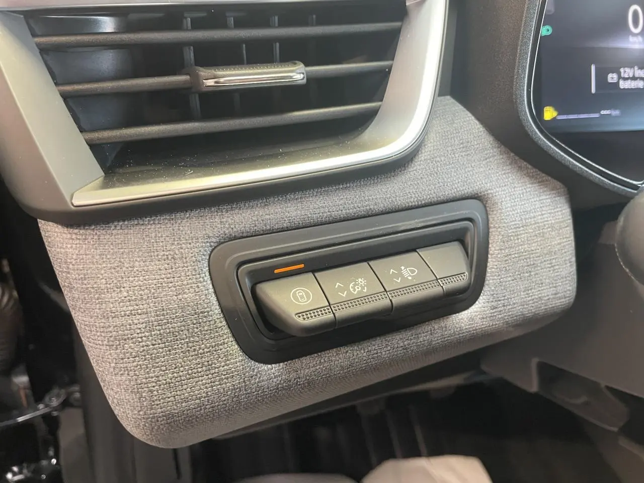 Détail des commandes d’éclairage et verrouillage sur la planche de bord tissu gris de la Renault Clio 2025.