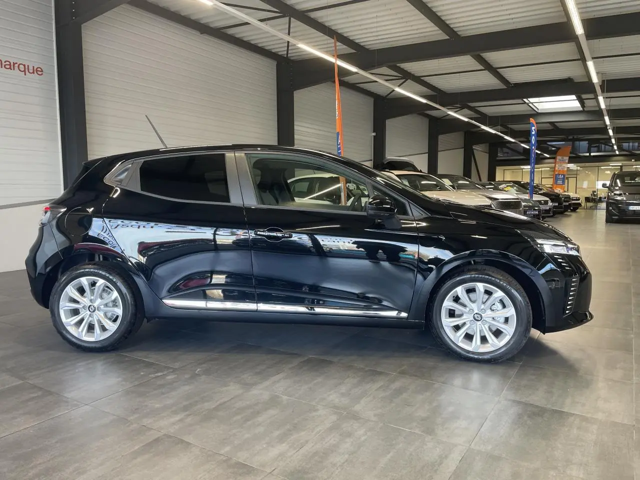 Renault Clio 1.5 Blue dCi 2025 vue de profil côté gauche, peinture noir étoilé avec jantes alu visibles.