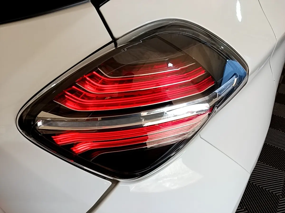 Gros plan sur le feu arrière droit rouge et blanc d'une Renault ZOE blanche, version Zen R110 de 2019.