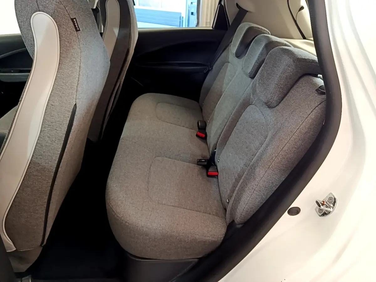 Vue intérieure côté droit sur la banquette arrière grise de la Renault ZOE Zen R110 blanche, avec sièges 3 places et appuie-têtes.