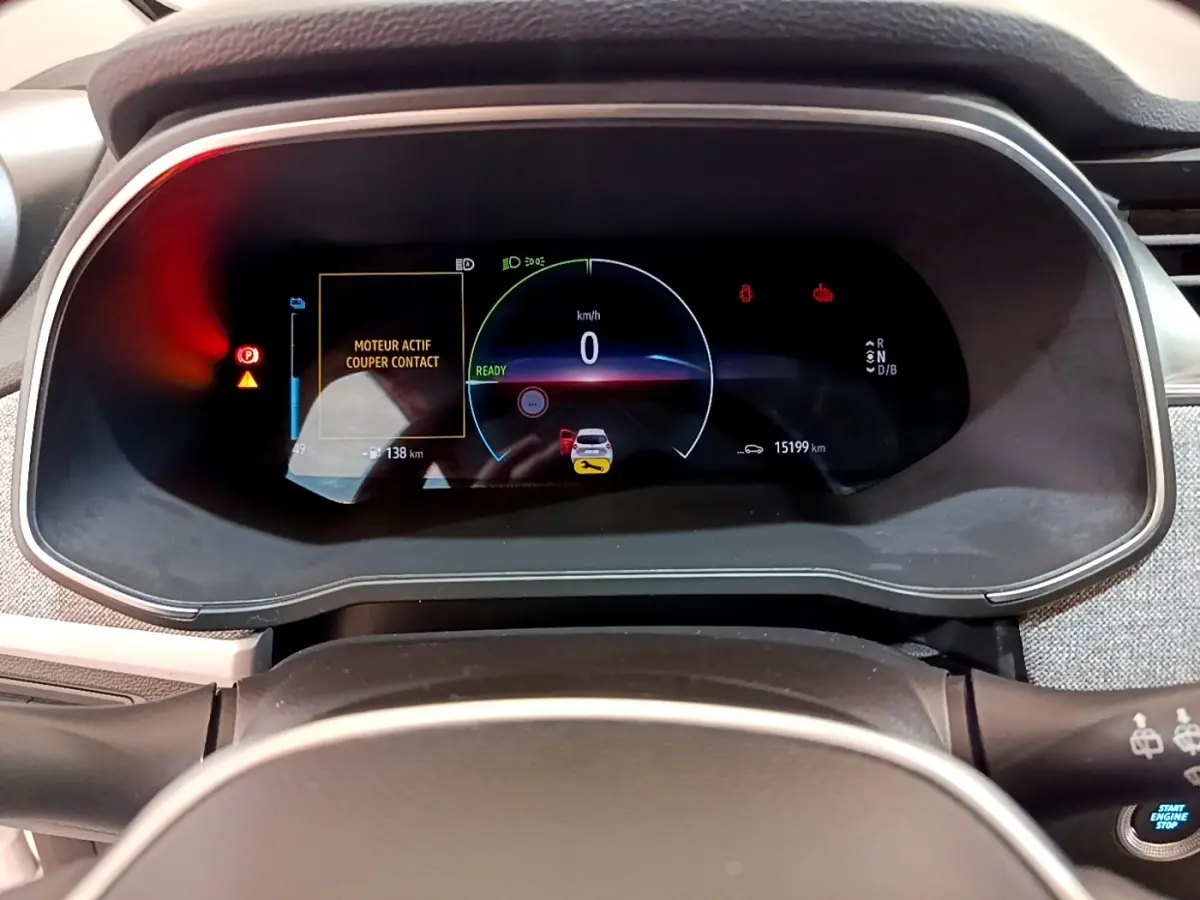 Vue rapprochée du combiné d'instruments numérique de la Renault ZOE blanche, affichant 0 km/h et alertes actives.