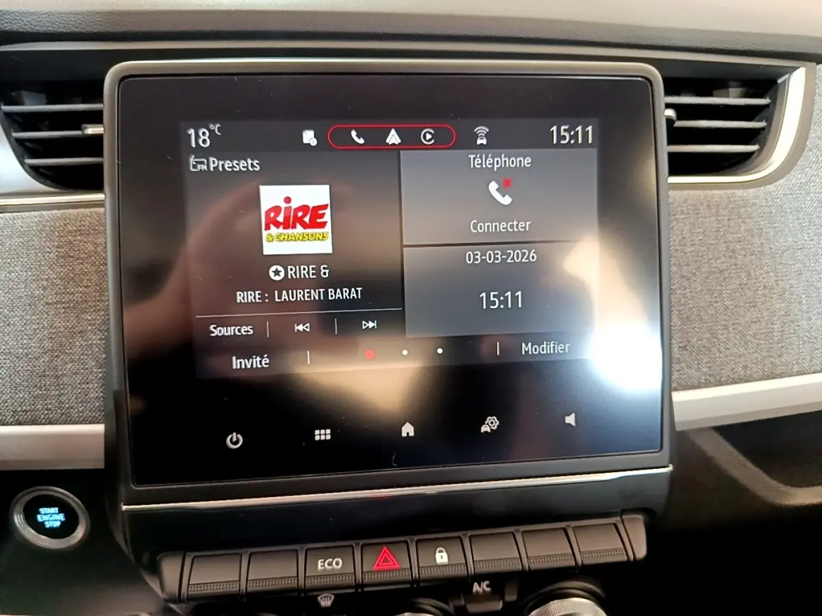 Écran tactile central de la Renault ZOE Zen R110 blanc, affichant la radio et les options téléphone, avec bouton démarrage visible.