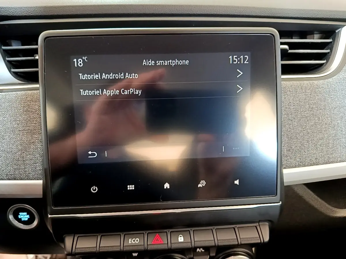 Écran tactile central de la Renault ZOE Zen R110 blanc, affichant tutoriels Android Auto et Apple CarPlay.