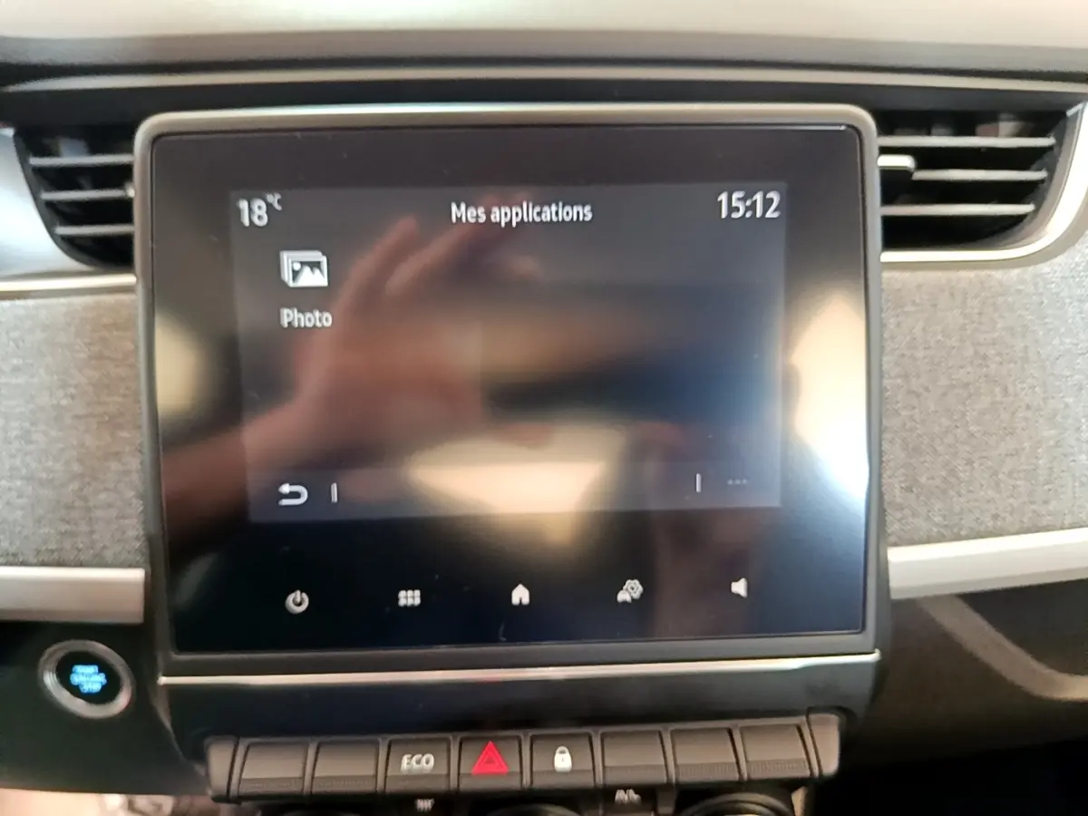 Écran tactile central de la Renault ZOE Zen R110 blanc, vue frontale du tableau de bord avec commandes et bouton démarrage.