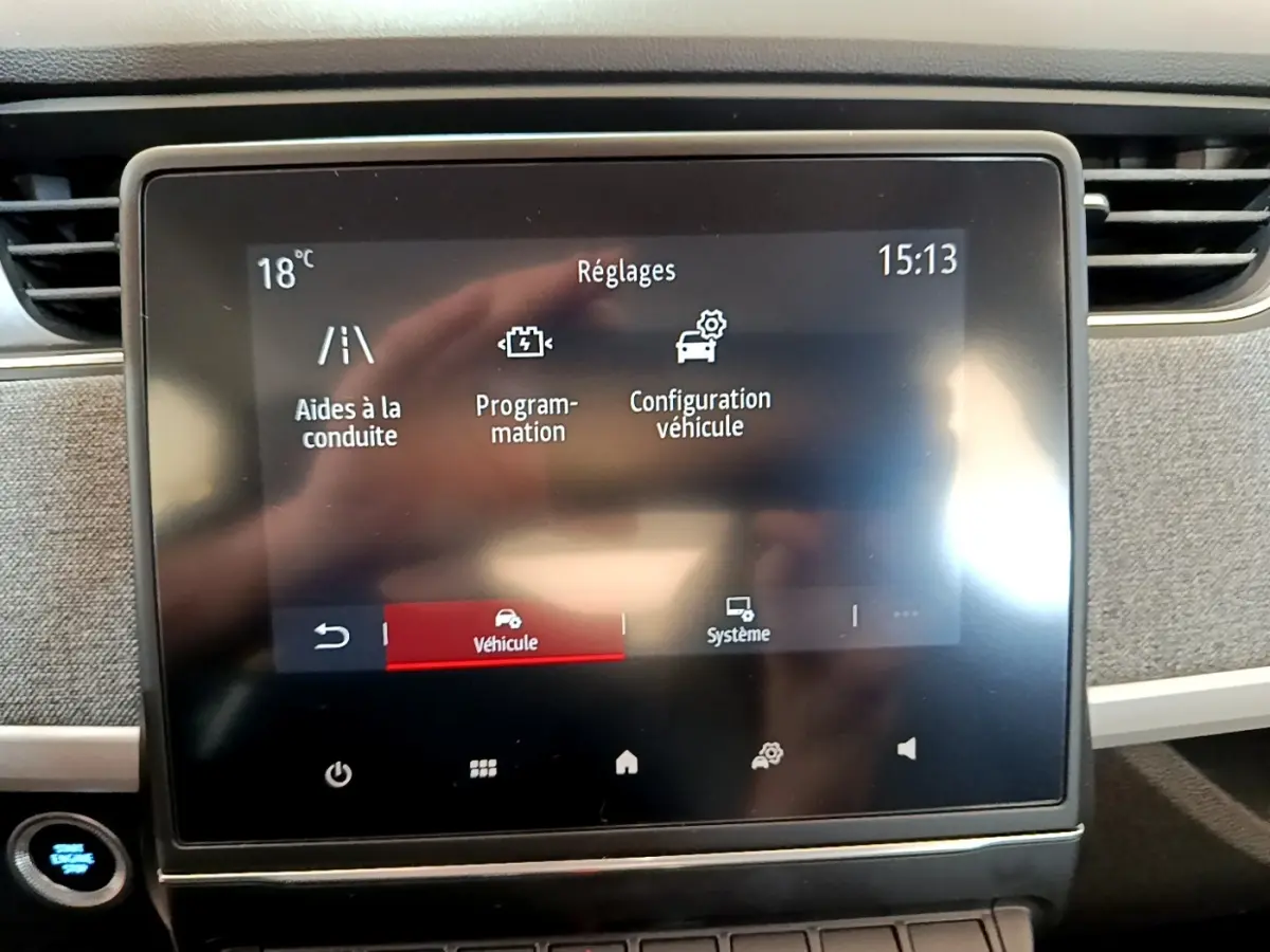Écran tactile central de la Renault ZOE blanc, affichant les réglages du véhicule en intérieur.