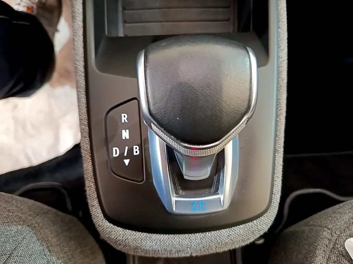 Le levier de vitesse noir et argenté de la Renault ZOE blanche, vue en gros plan sur la console centrale.