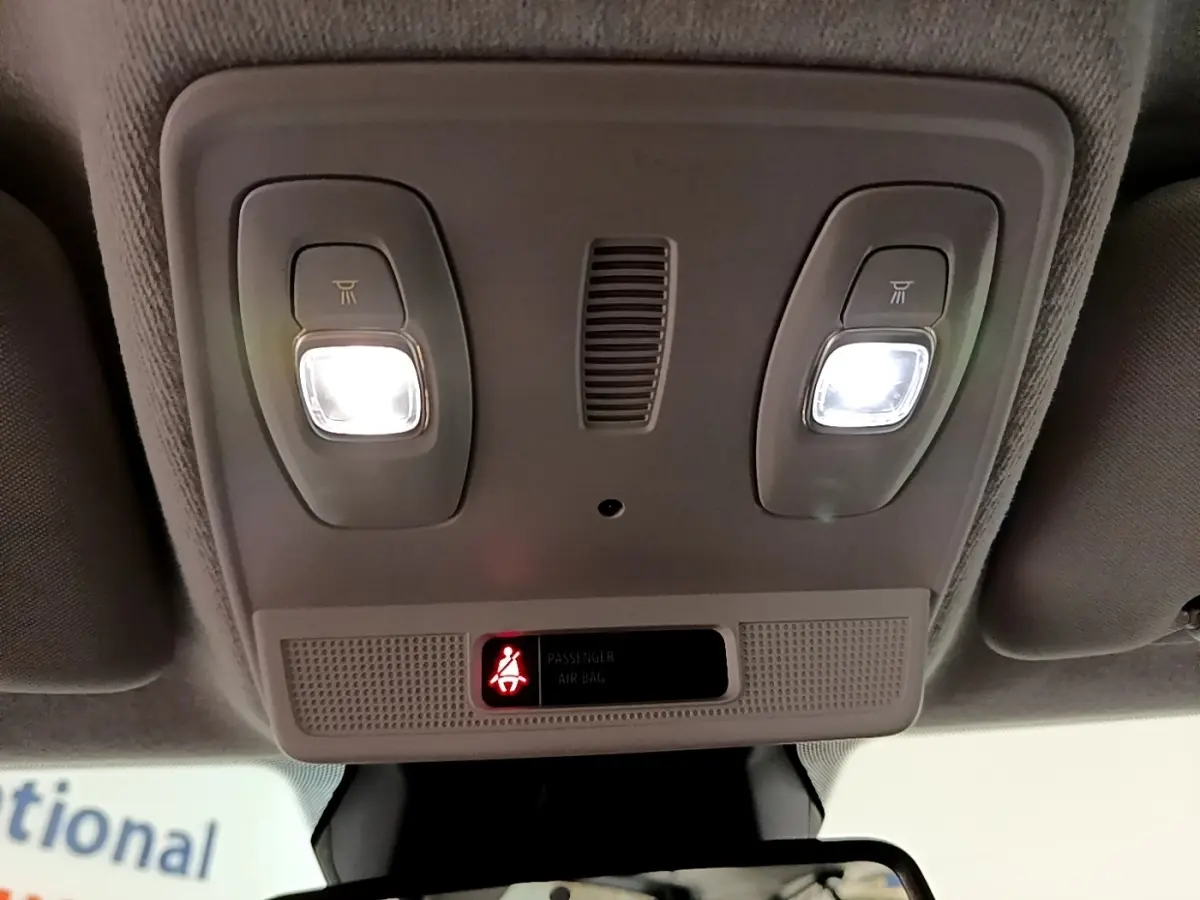 Vue intérieure du plafonnier avec éclairages allumés et témoin de ceinture passager sur une Renault ZOE blanche.