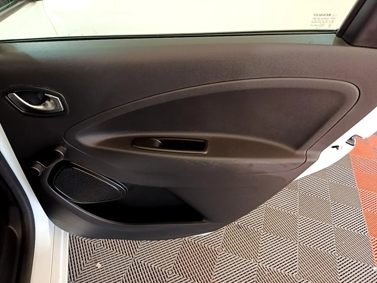 Vue rapprochée de la porte arrière droite blanche d'une Renault ZOE Zen R110 avec panneau intérieur noir et haut-parleur intégré.