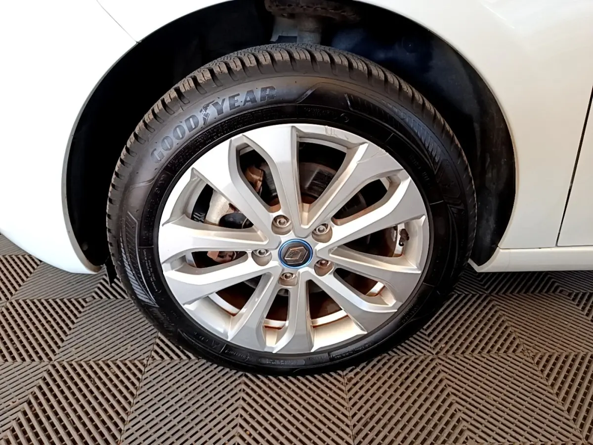 Gros plan sur la roue avant droite blanche d'une Renault ZOE 2019 avec jante alliage et logo Renault au centre.