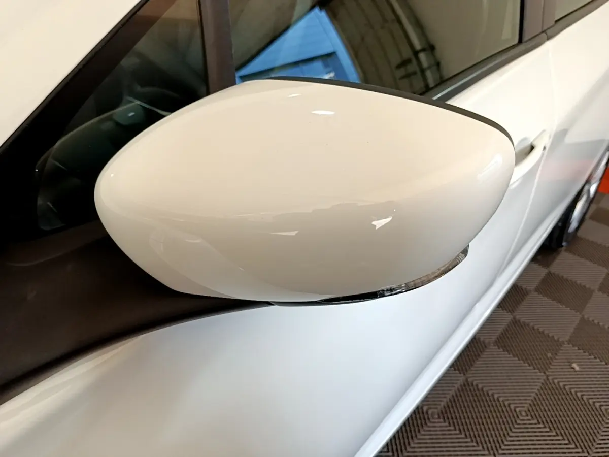 Rétroviseur blanc côté gauche d’une Renault ZOE Zen R110 2019, vue rapprochée sur la portière et la vitre.