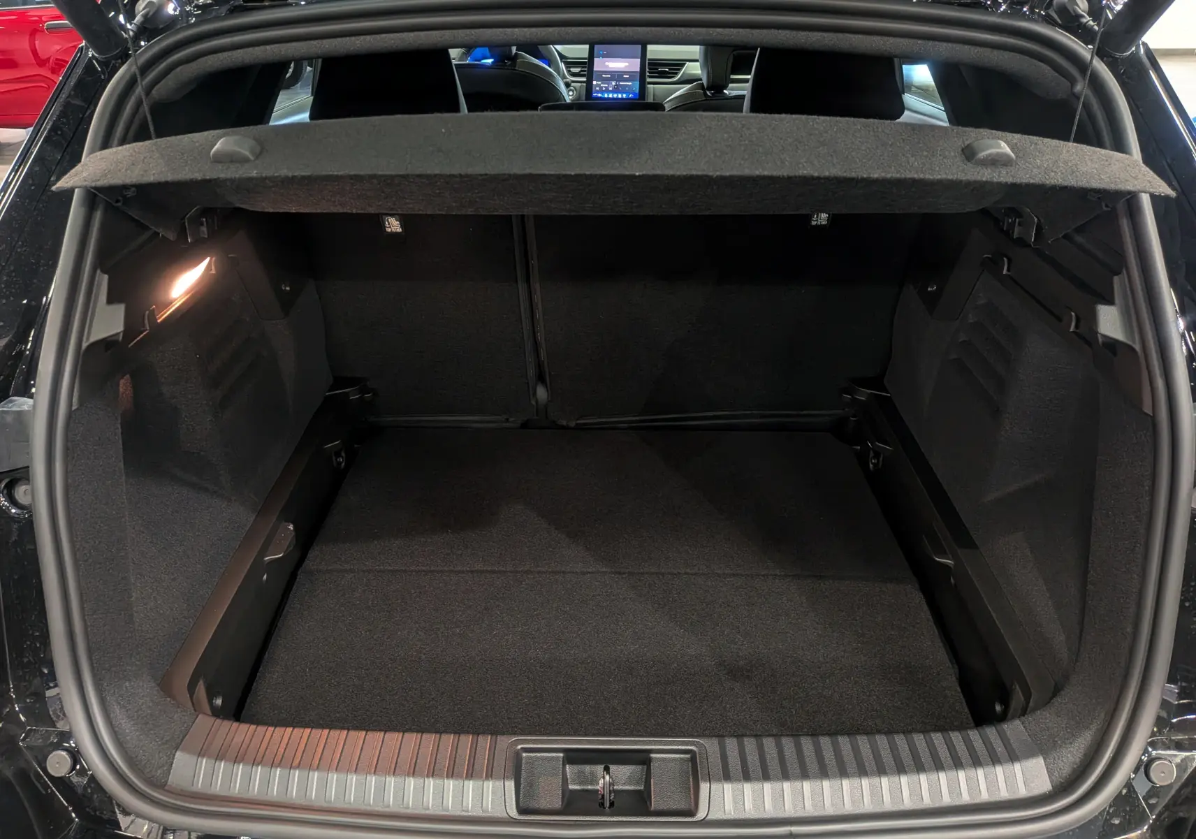 Coffre ouvert vu de l'arrière du Renault SYMBIOZ noir étoilé, montrant un espace de chargement spacieux et bien éclairé.