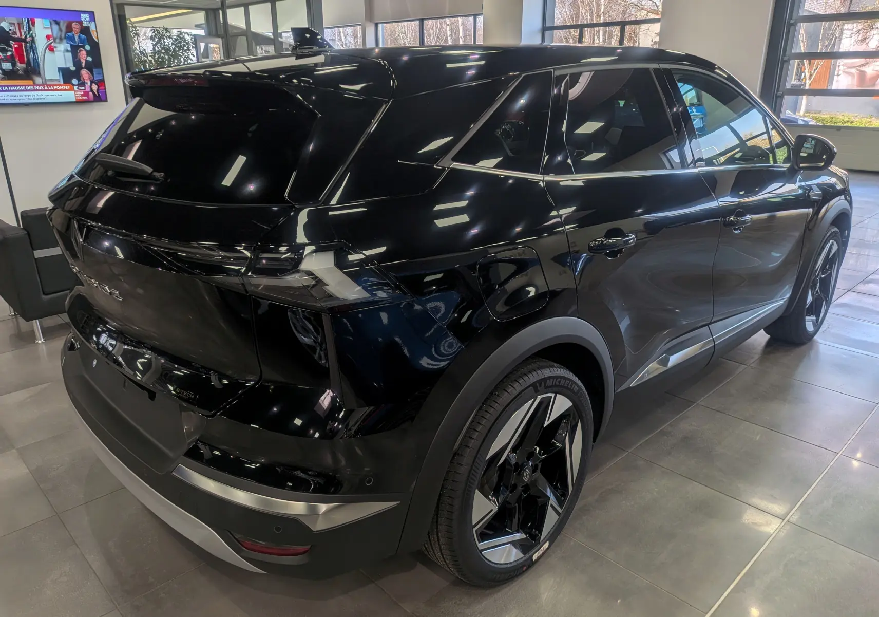 Vue 3/4 arrière droite du Renault SYMBIOZ E-Tech full hybrid noir étoilé, soulignant ses jantes bicolores et son design moderne.