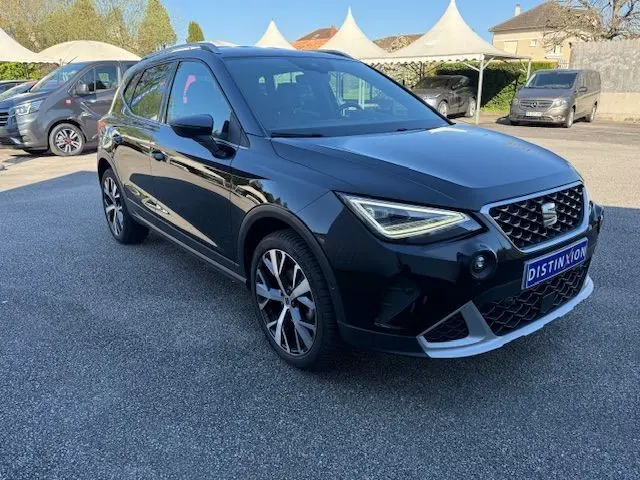 SEAT Arona noir avec toit gris, vue 3/4 avant droit, jantes alliage 18'' et projecteurs LED allumés.