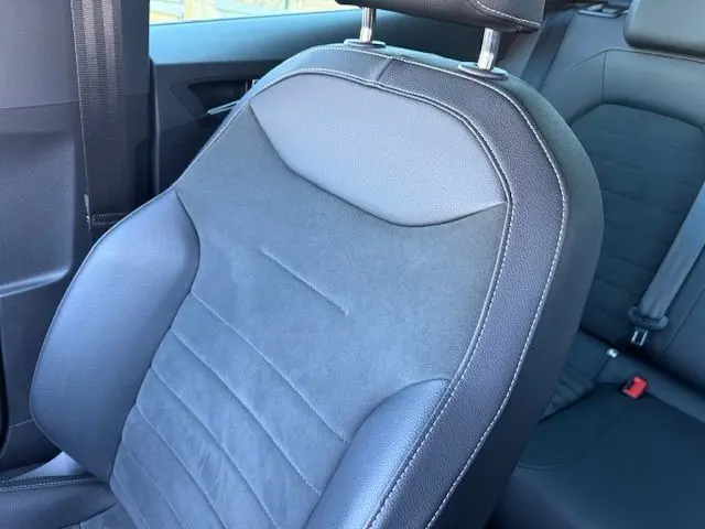 Gros plan sur le siège avant en suédine noire avec surpiqûres blanches du SEAT Arona 2022, intérieur côté gauche.