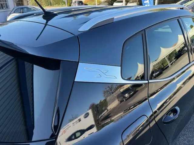 Gros plan sur la partie arrière droite noire du SEAT Arona 2022 avec toit gris et logo X sur montant chromé.