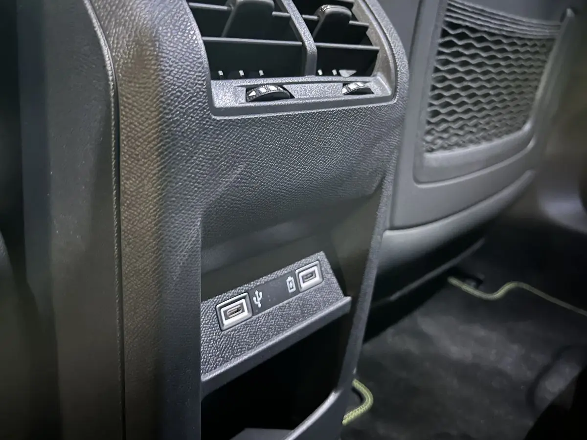 Vue rapprochée de la console arrière noire de la Peugeot 308 GT PHEV avec deux ports USB visibles.