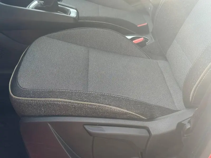 Gros plan sur le siège avant droit en tissu gris foncé du Renault Captur 2025, détails de couture visibles.